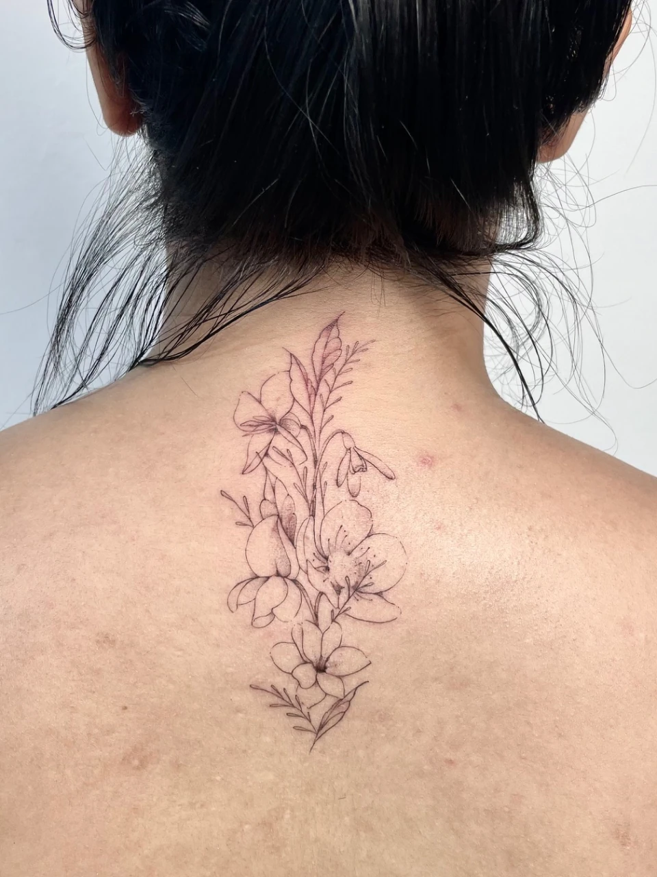 floral bouquet fine line tattoo on the back