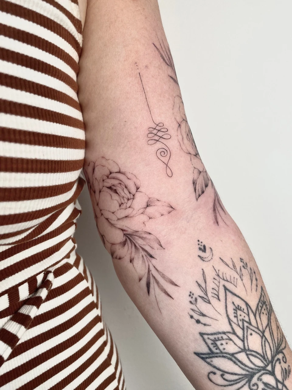 peonies with unalome fine line tattoo on arm