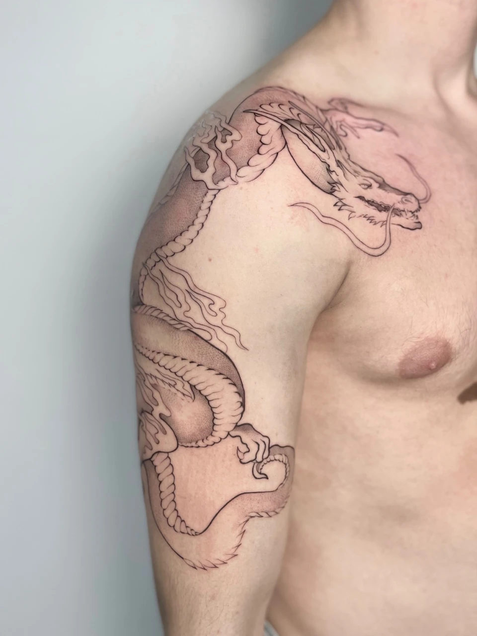 dragon fine line tattoo on shoulder