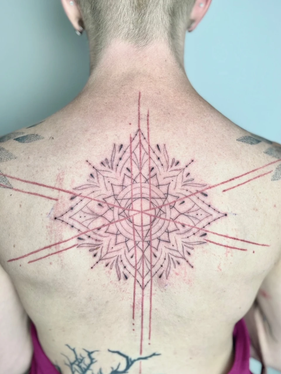 geometric ornament / mandala fine line tattoo on the back