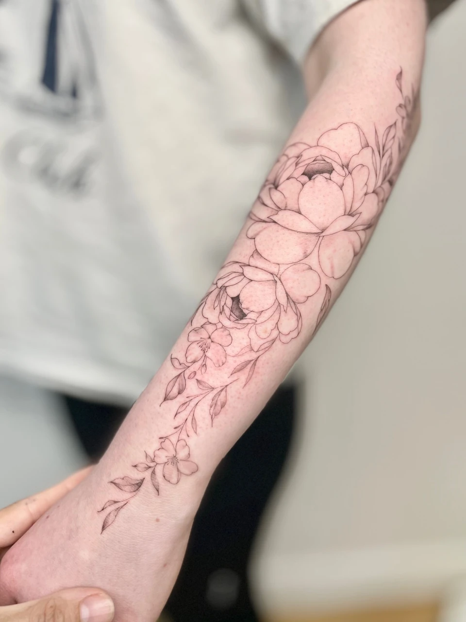 peonies fine line tattoo on forearm